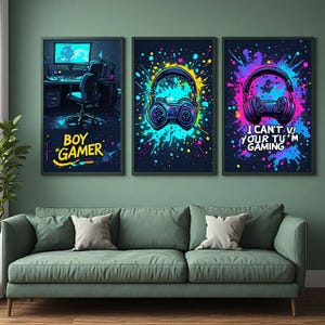 Peut inclure: Trois affiches murales rectangulaires sur le thème du jeu vidéo avec des éclaboussures de peinture néon. L'affiche de gauche montre un bureau avec le texte BOY GAMER. Celle du centre affiche un casque et une manette. Celle de droite montre un casque avec le texte I CAN'T VJ YOUR TU'M GAMING.
