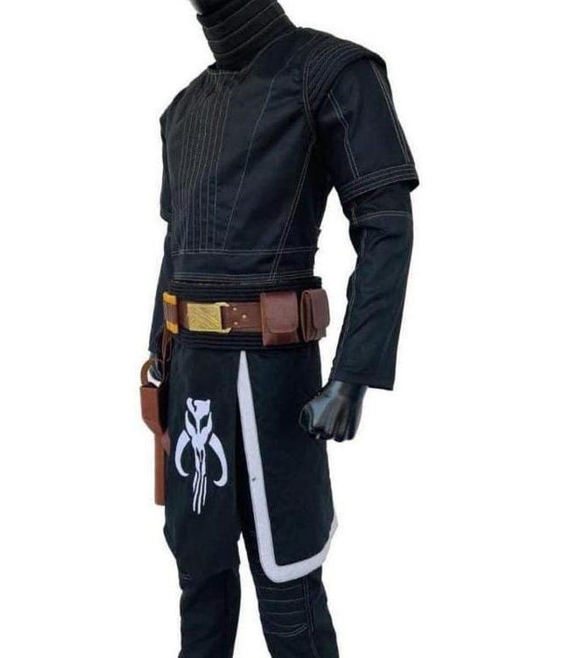 May include: A black long-sleeved tunic and pants set featuring a high collar, quilted shoulder detailing, and white stitching. A brown utility belt with a gold buckle and two attached pouches sits at the waist, alongside a white Mythosaur emblem.