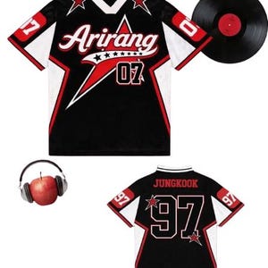 Peut inclure: Maillot noir et blanc avec des détails rouges, affichant le mot "Arirang" et le numéro "07". Un disque vinyle et un casque avec une pomme sont également présents. Le dos du maillot affiche "Jungkook" et le numéro "97".