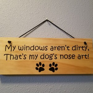 May include: A wooden sign with the text "My windows aren't dirty, That's my dog's nose art!" and two black paw prints.