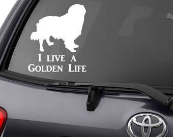 Op de afbeelding: Een wit silhouet van een Golden Retriever hond met de tekst "I live a Golden Life" op een grijs autoruit.
