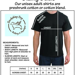 K&ouml;nnte beinhalten: Gr&ouml;&szlig;entabelle f&uuml;r Unisex-Shirts f&uuml;r Erwachsene mit Ma&szlig;en in Zoll. Die Tabelle enth&auml;lt Brust-, K&ouml;rper- und &Auml;rmell&auml;ngenmessungen f&uuml;r die Gr&ouml;&szlig;en S bis 3XL. Das Shirt ist schwarz, und der Text ist wei&szlig;.