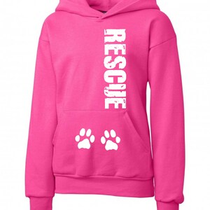 May include: Pink hooded sweatshirt with the word "RESCUE" printed vertically in white on the front and two white paw prints on the front pocket.