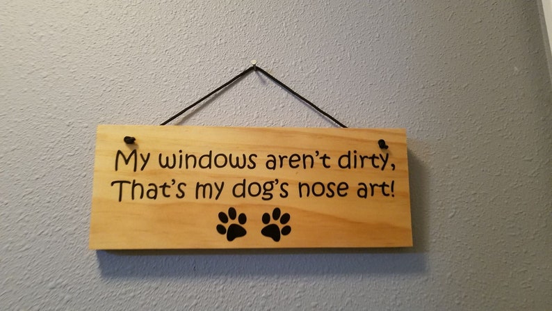 May include: A wooden sign with the text "My windows aren't dirty, That's my dog's nose art!" and two black paw prints.