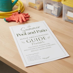 May include: A white paper document titled Summer Pool and Patio Setup Organization Guide Printable, featuring a pool opening checklist, alongside a teal watering can, a yellow garden hose, orange gloves, and three clear storage bins with yellow lids.