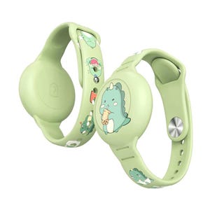 May include: Two light green smart watch bands. One band features a cartoon dinosaur drinking a beverage. The other band has smaller dinosaur illustrations. The bands are made of a flexible material and have a buckle closure.