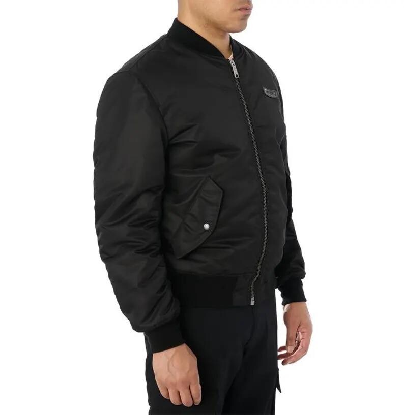 K&ouml;nnte beinhalten: Schwarze Bomberjacke mit geripptem Kragen, B&uuml;ndchen und Saum. Die Jacke hat einen Frontrei&szlig;verschluss, eine einzelne Tasche mit Druckknopfverschluss und einen kleinen Logoaufn&auml;her auf der Brust. Die Jacke ist aus glattem, gl&auml;nzendem Material.