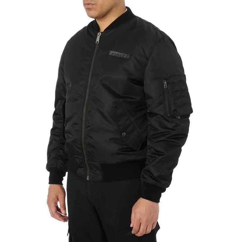 K&ouml;nnte beinhalten: Schwarze Bomberjacke mit geripptem Kragen, B&uuml;ndchen und Saum. Die Jacke hat einen Rei&szlig;verschluss, eine kleine Tasche am linken &Auml;rmel und einen Logoaufn&auml;her auf der Brust. Ein klassisches und vielseitiges Oberbekleidungsst&uuml;ck.