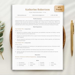 Könnte beinhalten: Eine professionelle Lebenslaufvorlage mit einem goldenen Stift und dekorativen Blättern. Der Lebenslauf ist hellbeige mit einer Kopfzeile mit der Aufschrift "Katherine Robertson" und enthält einen Abschnitt mit der Bezeichnung "ATS Friendly".