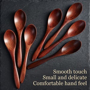 May include: A collection of seven wooden spoons with a rich, dark brown finish. The spoons are arranged on a dark, textured surface. The image includes text that reads "Smooth touch, Small and delicate, Comfortable hand feel."