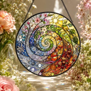 Peut inclure: Un capteur de soleil circulaire en vitrail présentant un motif en spirale vibrant qui illustre les quatre saisons. La pièce affiche des fleurs de cerisier roses, un soleil jaune vif, des feuilles vertes, un feuillage d'automne orange et des éléments hivernaux bleus.