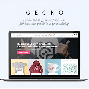 Könnte beinhalten: Ein Laptop zeigt eine Website mit dem Wort "GECKO" oben. Der Bildschirm zeigt eine Website mit dem Text "Design your own products? Create and sell custom products." Darunter Produktbeispiele: ein graues T-Shirt, ein roter Hoodie, eine weiße Tasse und ein Kissen.