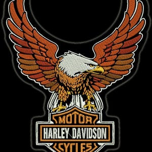 May include: An embroidered patch featuring a bald eagle with outstretched wings in shades of orange, brown, and white. Below the eagle is a black and orange emblem with the text MOTOR HARLEY-DAVIDSON CYCLES in white lettering on a black background.