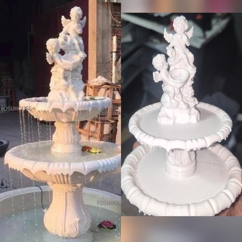 May include: A white two-tiered fountain featuring a sculptural topper of two cherubs. The fountain has a scalloped edge on each basin and a central pedestal base. Water flows from the top tier into the lower basin, with the text FOSUHOUSE visible.