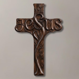 Pode incluir: Uma cruz de madeira castanho-escura com a palavra JESUS esculpida em letras grandes e negrito na barra horizontal. A secção vertical apresenta um relevo de uma videira com folhas e uma coroa de espinhos no centro da intersecção.