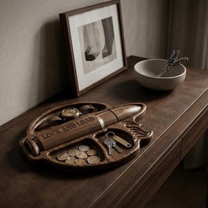 High-resolution CNC relief stl file for a tactical bullet valet tray. The model features deeply carved compartments for an EDC dump tray, holding a military-style watch, US coins, and keys. The central bullet relief is engraved with "LOCK AND LOAD." This detailed 3D woodworking file is perfect for creating custom man cave catchall tray gifts.