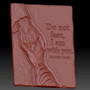 Pode incluir: Uma placa retangular de cor terracota com uma escultura em relevo de duas m&atilde;os estendidas uma para a outra. O texto "Do not fear, I am with you. ISAIAH 41:10" est&aacute; gravado no lado direito da superf&iacute;cie texturizada e irregular.
