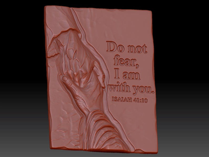 Pode incluir: Uma placa retangular de cor terracota com uma escultura em relevo de duas m&atilde;os estendidas uma para a outra. O texto "Do not fear, I am with you. ISAIAH 41:10" est&aacute; gravado no lado direito da superf&iacute;cie texturizada e irregular.