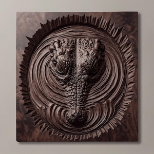 Puede incluir: Una placa de pared cuadrada de madera marrón oscuro que presenta una talla en relieve detallada de una cabeza de cocodrilo emergiendo del agua. El cocodrilo está centrado dentro de un patrón circular de ondas, rodeado de bordes tallados radiantes.