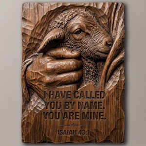 Puede incluir: Una placa de pared rectangular de madera marrón oscuro con una talla en relieve detallada de una mano sosteniendo suavemente un cordero. El texto "I HAVE CALLED YOU BY NAME. YOU ARE MINE. ISAIAH 43:1" está tallado en la sección inferior con un acabado de veta de madera texturizada.
