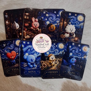 May include: A collection of eight rectangular cards featuring stylized cartoon characters set against dark blue, swirling night sky backgrounds. Each card displays a unique character, including Tata, Koya, Chimmy, and Mang, with a circular logo in the center reading ApotheCraft Studio Crafted with a dose of joy.