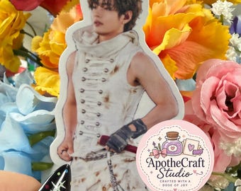May include: A die-cut sticker featuring a person with brown hair wearing a sleeveless white hooded top with front lacing and dark fingerless gloves. The sticker includes a circular logo with the text ApotheCraft Studio Crafted with a Dose of Joy.