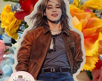 May include: A die-cut sticker featuring a person with long brown hair, wearing a brown leather jacket over a gray t-shirt, blue jeans, and a black belt. The person has their tongue slightly out. A small circular logo reads ApotheCraft Studio.