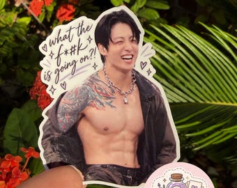 May include: A die-cut sticker featuring a smiling person with dark hair, a silver chain necklace, and a colorful arm tattoo, wearing an open black jacket. The text "what the f*#k is going on?!" is printed in black script with small star and heart icons.