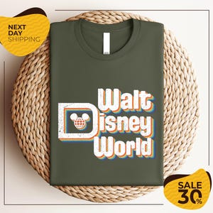 A green t-shirt with the text "Walt Disney World" printed on it, displayed on a woven basket.