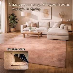 Puede incluir: Una alfombra grande y rectangular de color rosa en un salón. La alfombra está colocada debajo de un sofá seccional beige y una mesa de centro de madera. El texto "Cambia tu alfombra. No tu habitación. Ajuste perfecto. Antideslizante." está en la parte superior. La imagen muestra cómo encaja la alfombra.