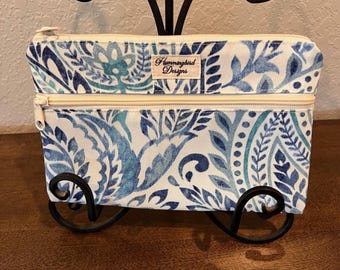 Bolso de lona con estampado paisley y dos compartimentos forrados con cremallera.