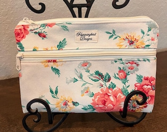 Bolso de lona con estampado floral y dos compartimentos forrados con cremallera.