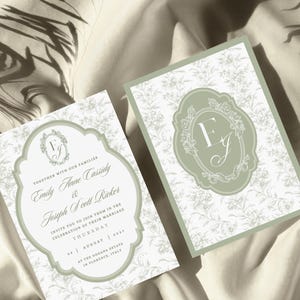 May include: Two rectangular wedding invitation cards featuring a sage green border and a white background with a delicate gray floral pattern. The cards display a central sage green ornate frame containing the initials EJ and wedding details.