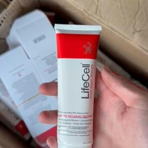 K&ouml;nnte beinhalten: Eine wei&szlig;e Tube mit LifeCell South Beach Skincare Anti-Aging-Behandlung mit rotem Deckel. Die Tube wird in der Hand einer Person gehalten. Das Produkt ist als konzentrierte Hautverj&uuml;ngungsbehandlung gekennzeichnet.