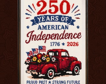 May include: Cross-stitch artwork in a black frame. The design celebrates 250 Years of American Independence, featuring a red truck filled with flowers and American flags. The text includes the years 1776 and 2026, with the phrase "Proud Past Strong Future."
