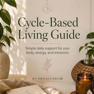 Puede incluir: Un libro titulado "Cycle-Based Living Guide" con el subtítulo "Apoyo diario simple para tu cuerpo, energía y emociones". El libro está sobre una superficie beige con una vela, cristales y plantas en el fondo.