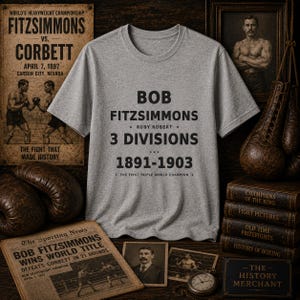 Könnte beinhalten: Ein graues meliertes T-Shirt mit schwarzem Text, der BOB FITZSIMMONS, RUBY ROBERT, 3 DIVISIONS, 1891-1903 und THE FIRST TRIPLE WORLD CHAMPION lautet. Das T-Shirt hat einen Rundhalsausschnitt und kurze Ärmel mit einem Grafikdesign im Vintage-Stil.