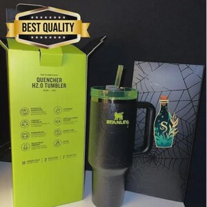 May include: A black Stanley Quencher H2.0 tumbler with a green lid and straw, next to its box. The box is lime green with product details. A decorative card with a bottle illustration is also present.