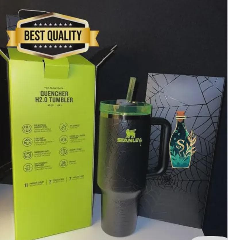 May include: A black Stanley Quencher H2.0 tumbler with a green lid and straw, next to its box. The box is lime green with product details. A decorative card with a bottle illustration is also present.