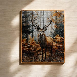 May include: A framed tapestry featuring a majestic deer in a forest setting. The deer has large antlers and is surrounded by trees with autumn foliage in shades of brown, orange, and green. The artwork is set against a light background.