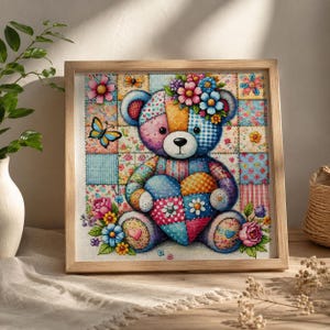 Pode incluir: Uma obra de ponto cruz emoldurada apresentando um urso de peluche de patchwork segurando um coração. O urso é composto por vários padrões florais e xadrez coloridos, adornado com uma coroa de flores e rodeado por borboletas e flores.