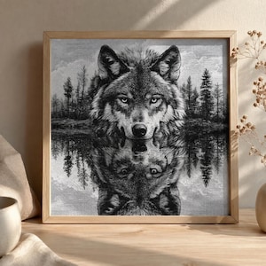 Peut inclure: Une œuvre d'art murale carrée encadrée représentant une illustration en noir et blanc d'une tête de loup centrée au-dessus de son propre reflet dans une eau calme. Le fond montre une forêt dense de grands pins sous un ciel nuageux, en niveaux de gris.
