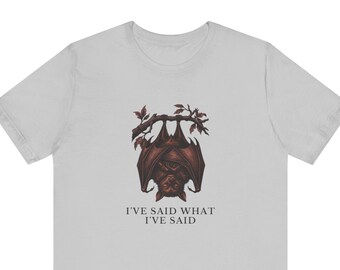 May include: A light gray short-sleeved t-shirt featuring a dark brown illustration of a bat hanging upside down from a branch. Below the bat, the text reads I'VE SAID WHAT I'VE SAID in a simple, dark, capitalized font centered on the chest.