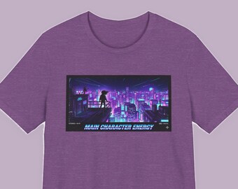 May include: A heather purple t-shirt featuring a rectangular graphic print of a silhouette standing on a rooftop overlooking a neon-lit cyberpunk city at night. The text MAIN CHARACTER ENERGY is printed in a bold, stylized font below the city scene.