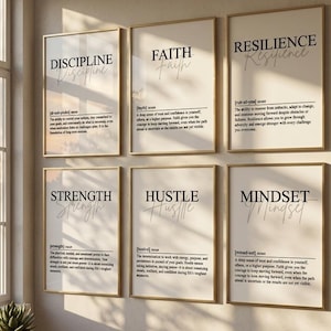 Peut inclure: Un ensemble de six affiches murales encadrées présentant des définitions de style dictionnaire pour les mots Discipline, Faith, Resilience, Strength, Hustle et Mindset. Chaque affiche a un fond clair avec du texte noir et un cadre en bois fin.