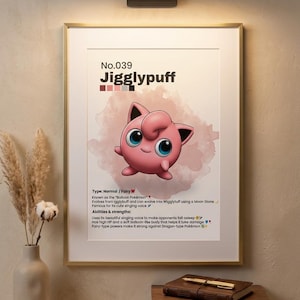 May include: A framed poster featuring Jigglypuff, a pink Pok&eacute;mon with large blue eyes. The poster includes the number 039, the Pok&eacute;mon's name, and details about its type, abilities, and strengths. The poster is in a gold frame, with a wooden shelf and a vase of dried flowers in the foreground.