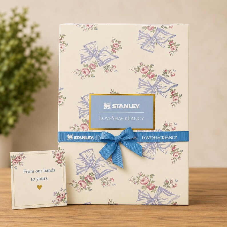Pu&ograve; includere: Una confezione regalo color crema con un motivo floreale a fiocco blu e rosa. La scatola ha un nastro e un fiocco blu, con la scritta "STANLEY LOVESHACKFANCY". Una piccola carta recita "Dalle nostre mani alle vostre."