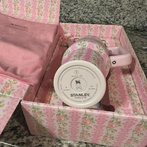 Pu&ograve; includere: Una tazza Stanley rosa floreale con manico, presentata in una confezione regalo abbinata. La tazza ha una capacit&agrave; di 1,18L. La scatola e la tazza presentano un motivo floreale rosa. La tazza &egrave; progettata a Seattle, WA, e prodotta in Cina.