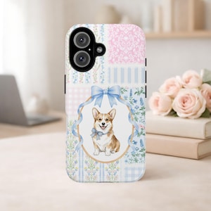 Puede incluir: Una funda para teléfono con una ilustración central de un perro Corgi de color canela y blanco con una pajarita de cuadros azules, enmarcado por una cinta azul claro y un borde ovalado. El fondo tiene un patrón de parches con flores rosas y azules.