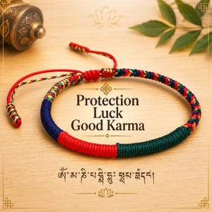 Puede incluir: Una pulsera de cordón trenzado con secciones de hilo rojo, azul oscuro y verde oscuro, con un patrón tejido multicolor. El texto "Protection Luck Good Karma" y escritura tibetana están impresos en el centro de la pulsera circular.